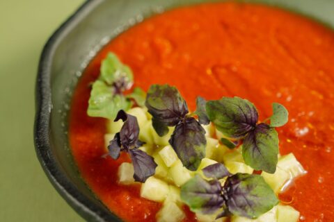 Gazpacho andaluz servido en un cuenco con hierbas frescas