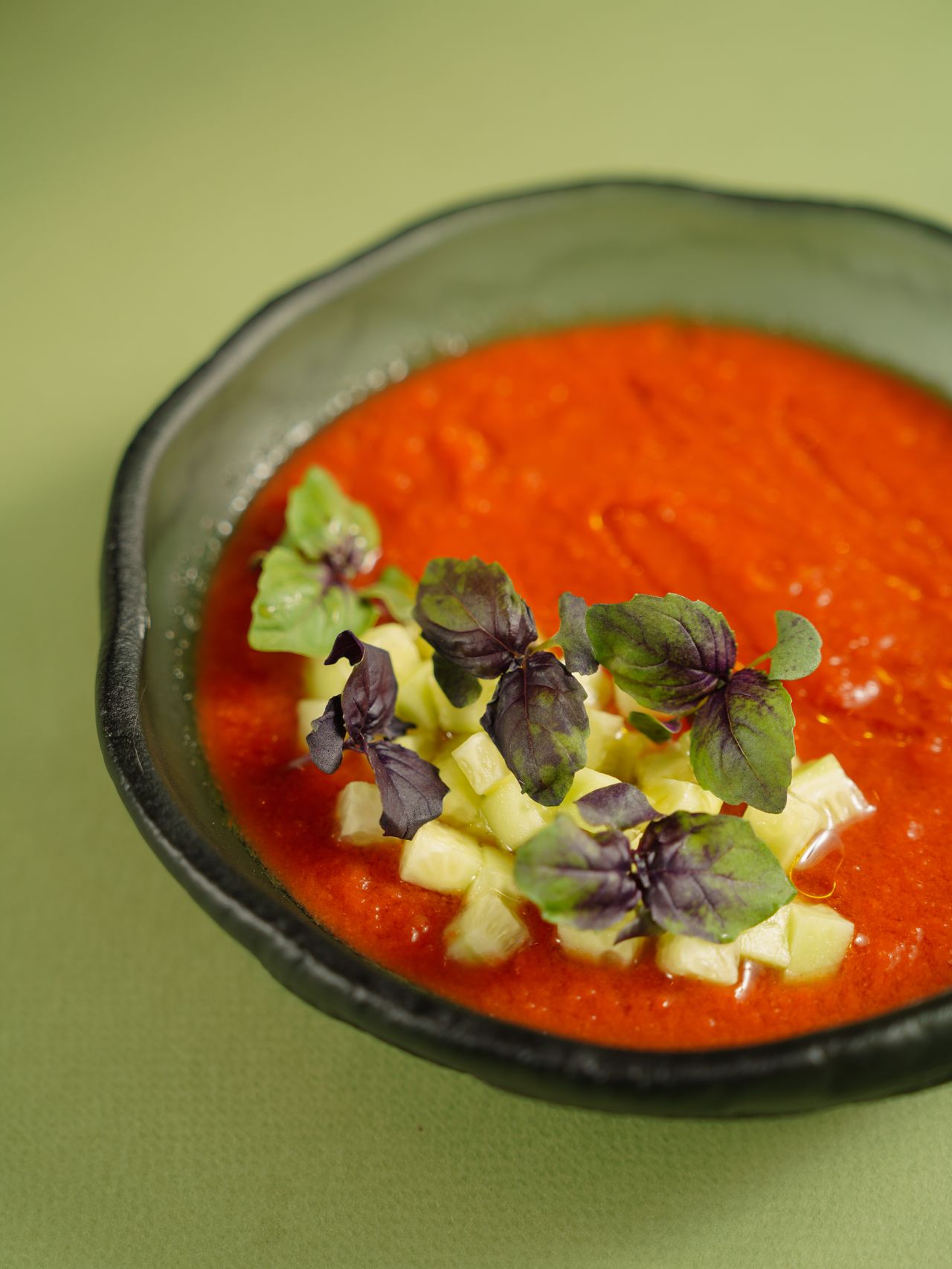 Gazpacho andaluz servido en un cuenco con hierbas frescas