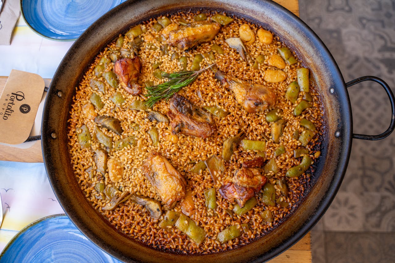 Paella valenciana tradicional con pollo y verduras en paellera