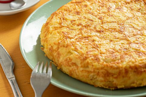 Tortilla de patatas española jugosa cortada en un plato